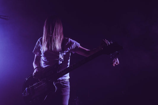 woman in white shirt playing electric guitar