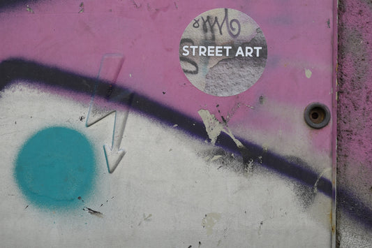 a wall with graffiti on it and a street art sticker on it