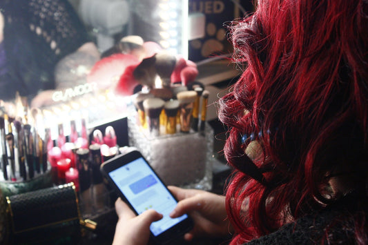 a woman with red hair is looking at her cell phone
