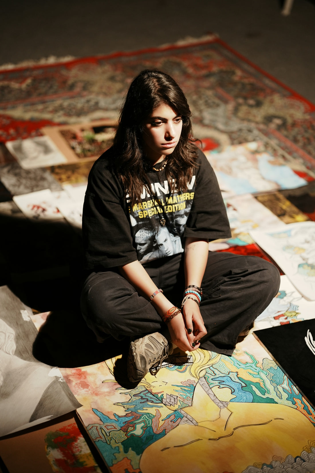 Young artist sitting amidst her artwork