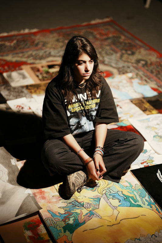 Young artist sitting amidst her artwork