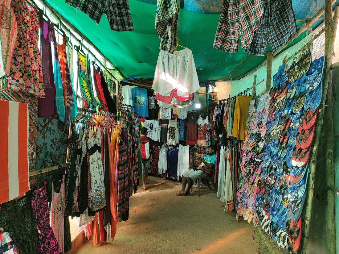 Colorful clothing and flip-flops displayed at a market stall.