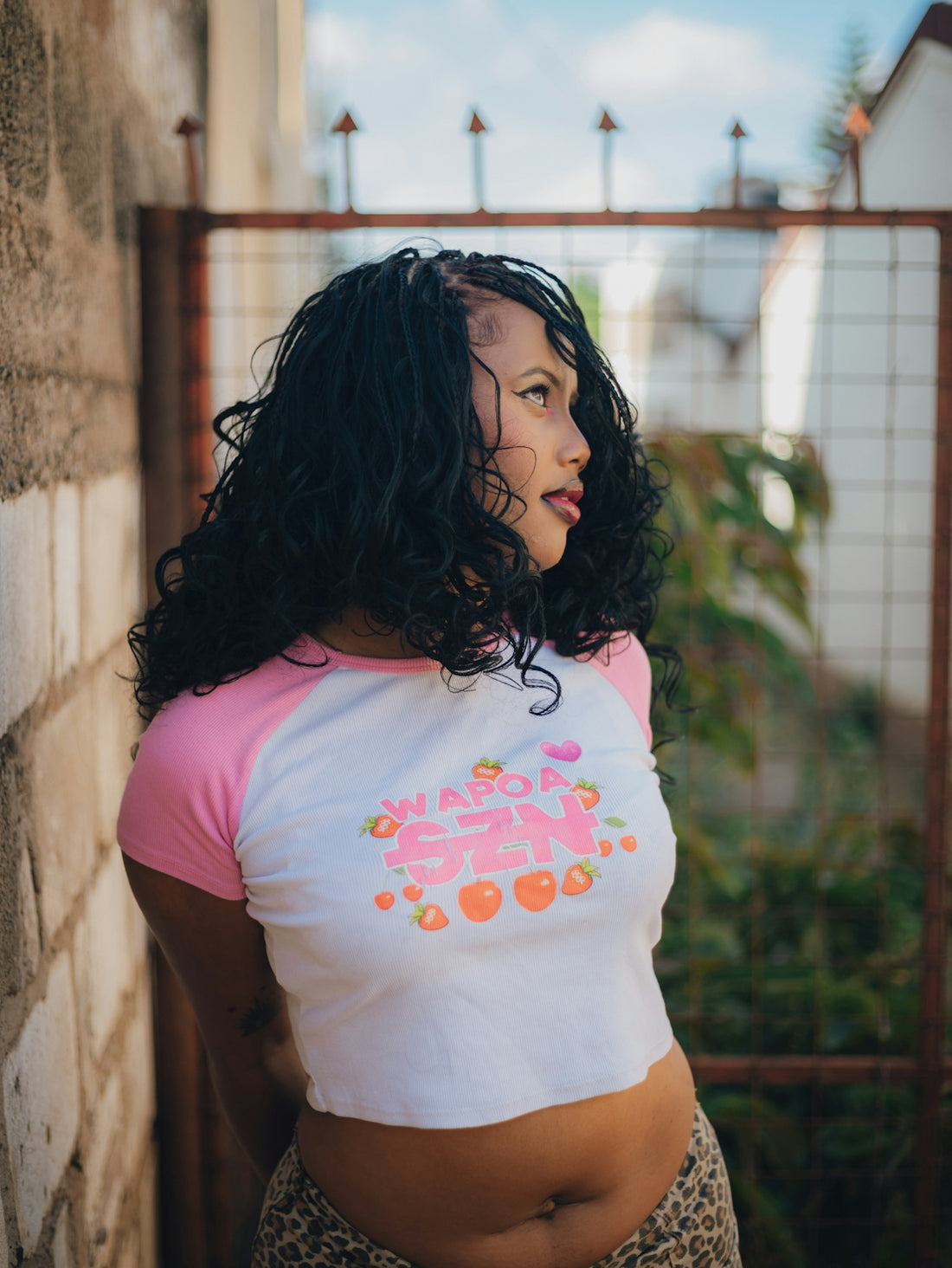 Woman with braided hair wearing a pink and white shirt.